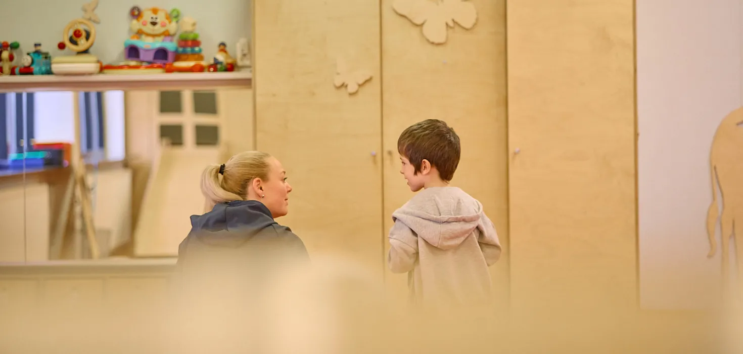 Kona og barn vísa í bak