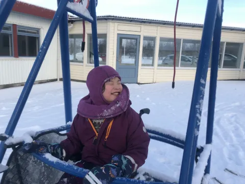 Stelpa í hjólastólarólu um vetur