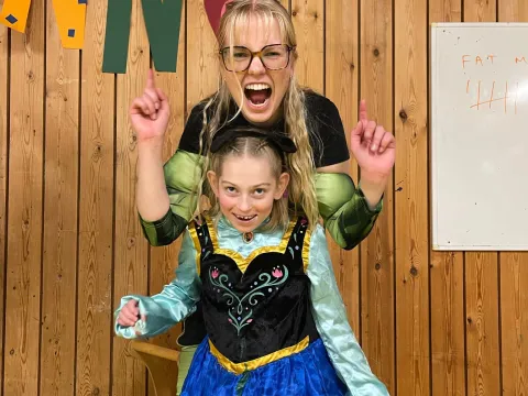 tvær upp á sviði í búningum