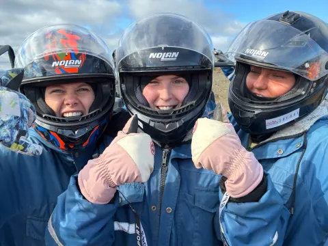 Þrjár glaðar með stóran hjálm og í bláum kuldagalla eftir Buggy ferð