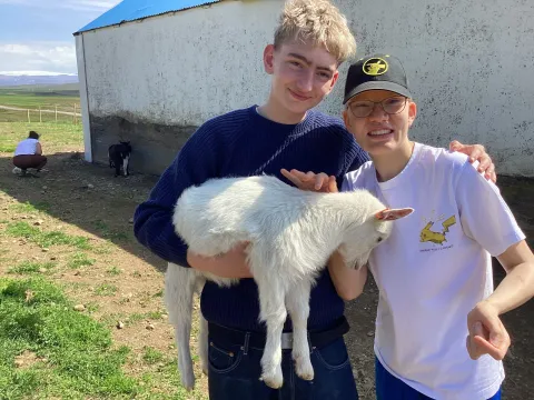 Tvö brosandi haldandi á hvítum kiðling