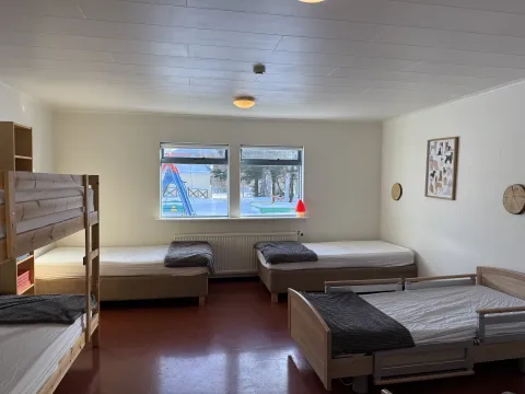 Mynd af græna herbergi á rauða gangi, koja og rúm