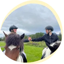 kids on horseback holding hands