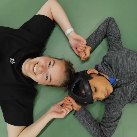 woman holding hands with boy with helmet