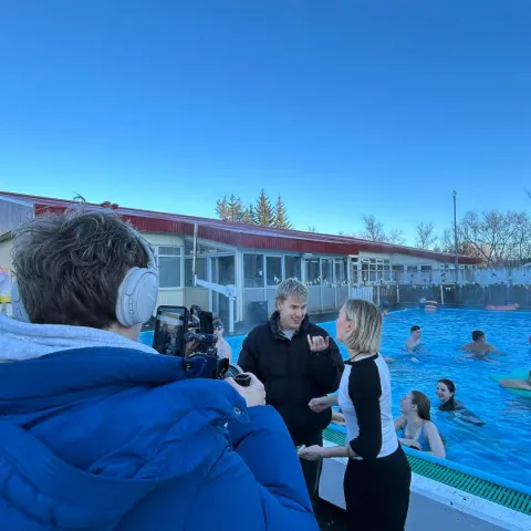 man filming kids pool party