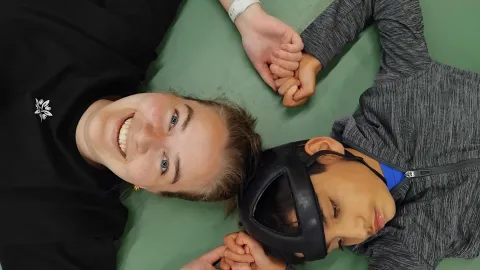 woman holding hands with boy with helmet