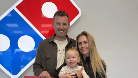 Fjölskylda úr hópi notenda Gló Æfingastöðvar heldur á styrktarávísun frá Domino’s að fjárhæð 6.989.109 kr. sem safnaðist með Góðgerðarpizzunni 2026.